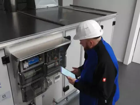 Ein Arbeiter steht an einer Maschine und überbacht