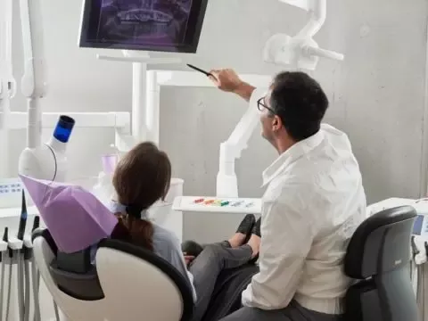 Ein Arzt schaut mit seiner Patientin auf ein Monito